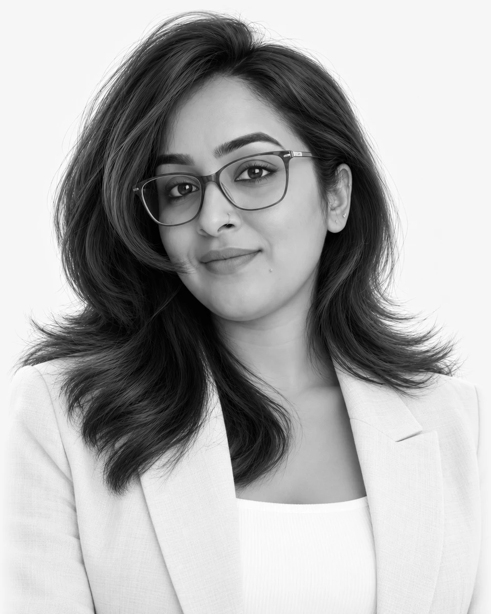 Portrait of Priya Duraikannu in glasses and a cream blazer
